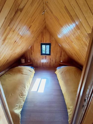 a room with two beds in a wooden cabin at La roulotte géante in Le Tampon