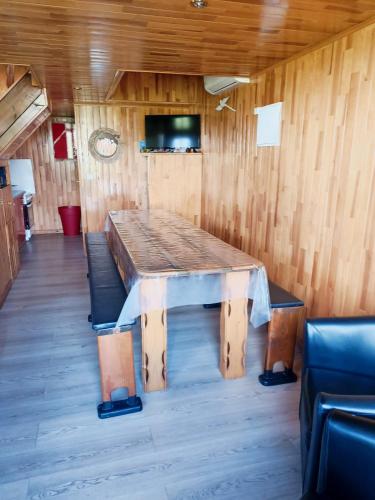 a large wooden table in a room with chairs at La roulotte géante in Le Tampon