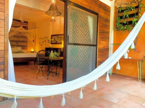 Hotel Casa Mixteca في زيبوليت: أرجوحة في غرفة مع طاولة وغرفة نوم