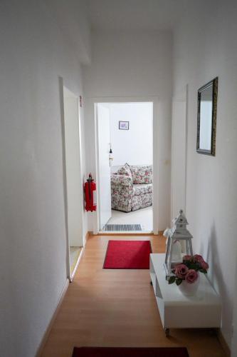a hallway with a room with a couch and a red rug at Cafe Alice & Pension GmbH in Potsdam