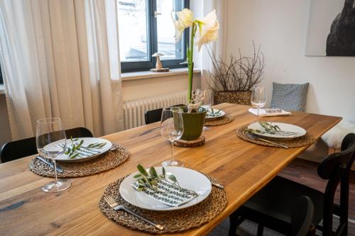 una mesa de madera con platos y copas de vino. en Kleines charmantes Haus am See, en Dießen am Ammersee