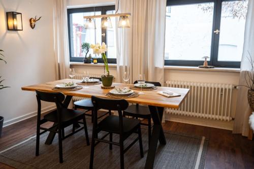 comedor con mesa de madera y sillas en Kleines charmantes Haus am See, en Dießen am Ammersee