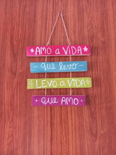 a group of signs hanging on a wooden wall at Pousada Harmonia in Tamandaré