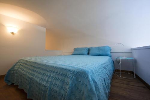 a bedroom with a bed with a blue comforter at B&B Viacampo6 in Atrani