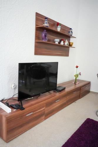 a flat screen tv sitting on top of a wooden entertainment center at Cafe Alice & Pension GmbH in Potsdam
