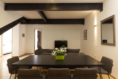 a dining room with a black table and chairs at El Doce by HomiRent in Laborcillas