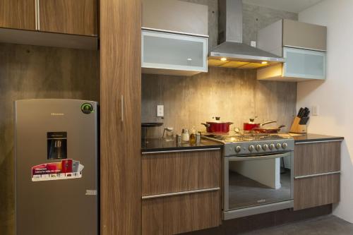 a kitchen with a refrigerator and a stove at El Doce by HomiRent in Laborcillas