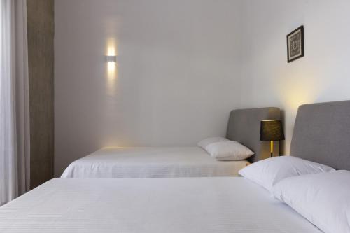 a bedroom with two beds and a chair at El Doce by HomiRent in Laborcillas