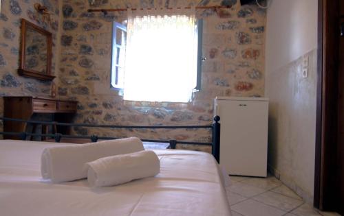 a bedroom with two beds and a window and a refrigerator at Marathos Bay in Kokkala