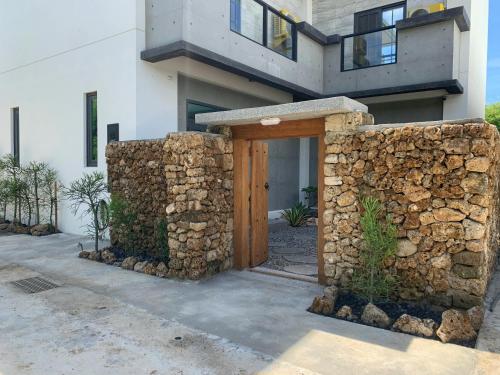 Casa con pared de piedra y puerta de madera en 砝泥民宿 6-12位包棟6間雙人房訂房前加line 有優惠, en Magong