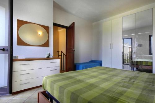 a bedroom with a green and white bed and a dresser at Le Villette di Capo Testa in Santa Teresa Gallura