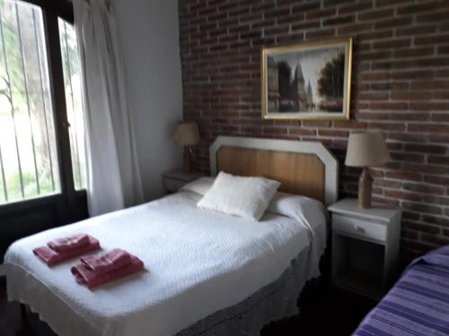 a bedroom with a bed with two towels on it at Haras L'Etalon in Pergamino