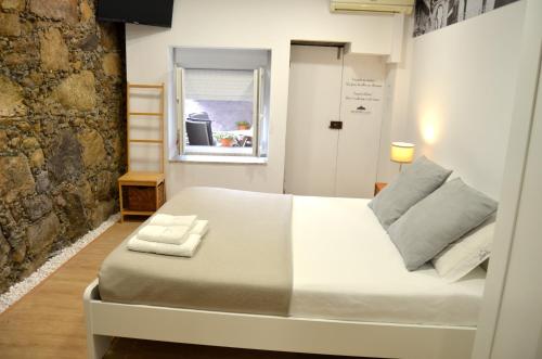 a bedroom with a large white bed with a window at SÃO VICTOR Studios HISTORIC CENTER in Braga
