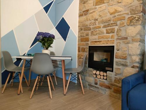 salon ze stołem i kominkiem w obiekcie La Petite Maison w mieście Pietrapertosa