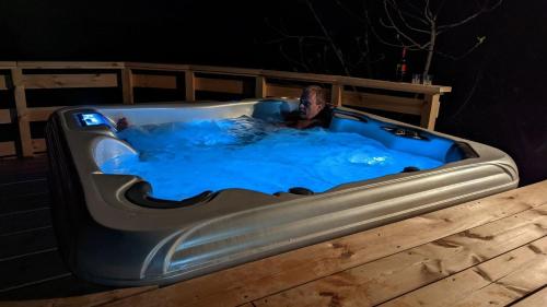 a man in a hot tub with blue water at Ursteirerhof - Familie Kerschbaumer in Palsdorf