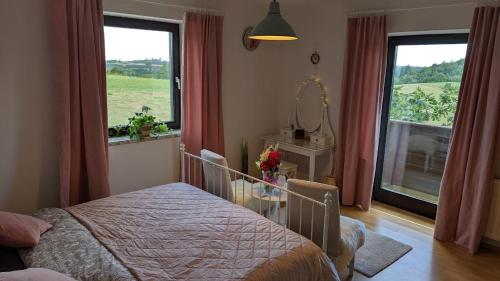 a bedroom with a bed and a large window at Ursteirerhof - Familie Kerschbaumer in Palsdorf