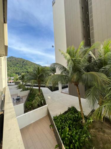 a courtyard with palm trees in a building at By The Sea Beachfront Designer Suites Penang - Managed by Art of Tree in Batu Ferringhi