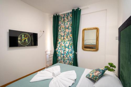 Schlafzimmer mit einem Bett und einem Fenster mit grünen Vorhängen in der Unterkunft Vitti's Home Verona 3 in Verona