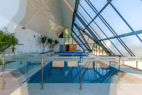 una piscina cubierta con paredes de cristal y techo en Apartment with a balcony and a pool - Welkeys, en Deauville