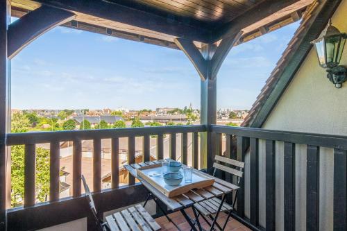 balcón con mesa y sillas en la terraza en Apartment with a balcony and a pool - Welkeys, en Deauville