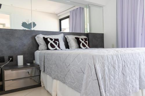 een slaapkamer met een groot bed met een grijs hoofdeinde bij Landscape VIP Fortaleza in Fortaleza