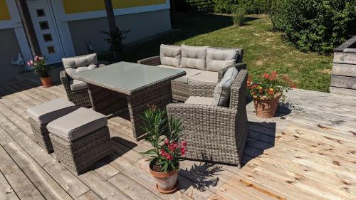 a wicker table and chairs on a wooden deck at Ursteirerhof - Familie Kerschbaumer in Palsdorf
