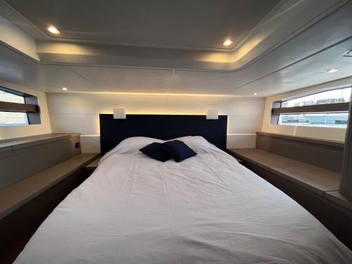 a bed in the middle of a room with two windows at Puissance, Elegance et Style, Yacht à Deauville in Deauville