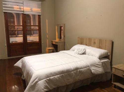 1 dormitorio con 1 cama grande con sábanas blancas en CASA AIDA LUZ, en Cuenca