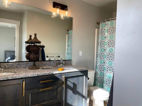 a bathroom with a sink and a mirror at Lovely Condo! W/ free recreational vehicle parking in Garden City