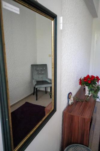 a mirror on a wall with a chair in a room at Cafe Alice & Pension GmbH in Potsdam