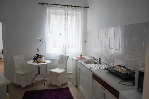 a kitchen with white cabinets and a sink and a window at Cafe Alice & Pension GmbH in Potsdam