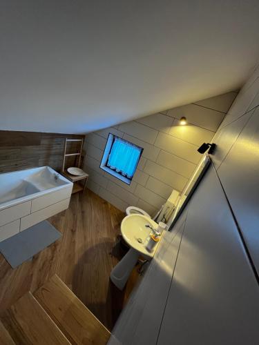 łazienka z umywalką, toaletą i oknem w obiekcie Holiday house Vukelic w mieście Mrkopalj