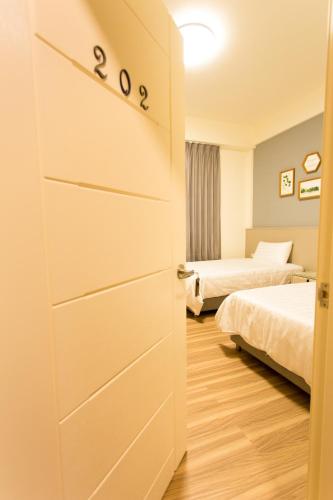 a bedroom with two beds and a door with numbers on it at 喜苑民宿 in Jinhu