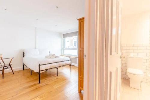 a bedroom with a bed and a table and a window at Spacious 1 Bedroom Apartment in Vibrant Angel in London