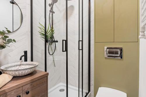 a bathroom with a shower and a sink at West Side Piotrkowska Apartment in Łódź
