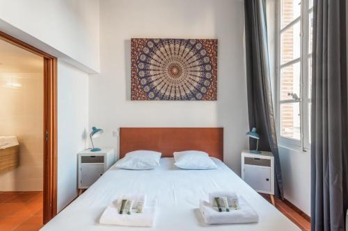Superb apartment located on the main square - Toulouse - Welkeys في تولوز: غرفة نوم عليها سرير وفوط