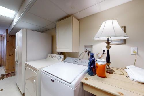 eine Küche mit einer Waschmaschine und einer Lampe auf der Theke in der Unterkunft Shang-Rye-La in Rye