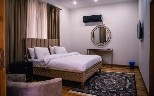 1 dormitorio con 1 cama grande y espejo en ISLE OF HIGHLAND TOURS Guest House, en Gilgit