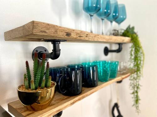 a shelf with blue and green cups and a cactus at CASA SOLE - Apartamento Playa San Juan NR. 4 in Guía de Isora