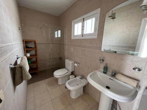 y baño con aseo blanco y lavamanos. en Oasis Blue - beautiful 1 bedroom apartment on private complex with pool, en Tías