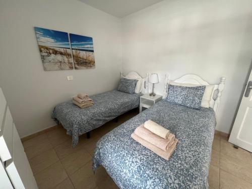 um quarto com 2 camas individuais e uma cadeira em Oasis Blue - beautiful 1 bedroom apartment on private complex with pool em Tías
