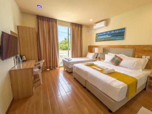 um quarto de hotel com duas camas e uma secretária em Rehendhi Villa em Maafushi