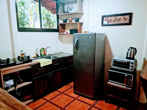 cocina con nevera de acero inoxidable y microondas en Jungle Beach Bungalow with AC & Fiber optic, en Puerto Viejo