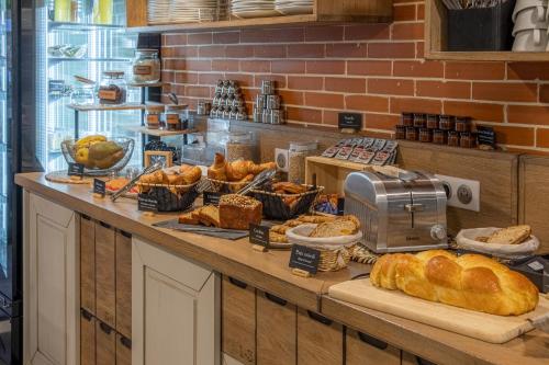a bakery with bread and pastries on a counter at The Originals City, Ax Hotel, La Châtaigneraie in La Châtaigneraie