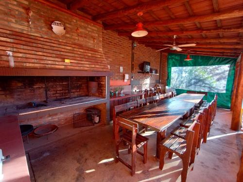 a dining room with a large wooden table and chairs at Hosteria Valle Azul in Villa del Dique