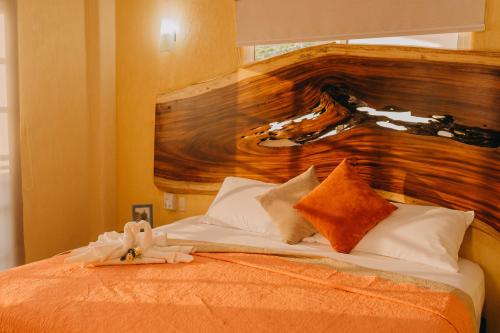 a bedroom with a bed with a wooden head board at Primavera Suites in Zihuatanejo