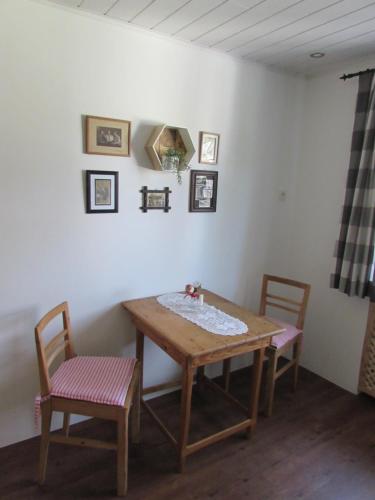 einen Holztisch und zwei Stühle in einem Zimmer in der Unterkunft Bachhäusl in Hof bei Salzburg