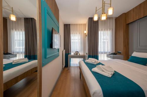 Habitación de hotel con 2 camas con detalles en azul en Lynda Hotel en Estambul