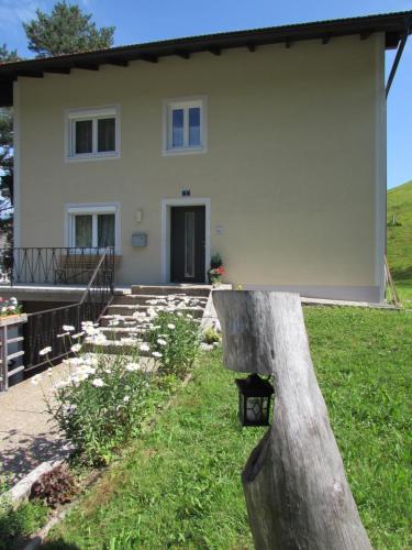 ein großes weißes Haus mit einem Gebäude in der Unterkunft Bachhäusl in Hof bei Salzburg