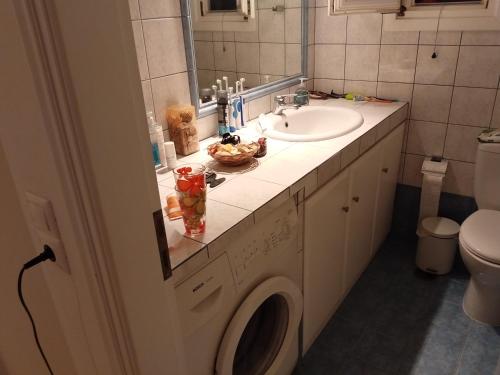 a bathroom with a sink and a washing machine at HOUSE 3Bedroom Maisonette ΕΞΟΧΙΚΟ Alyki PAROS 50m from BEACH ideal for families in Aliki